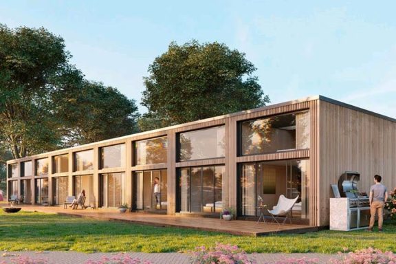 Moderne Holzarchitektur mit großen Fenstern in einer grünen Umgebung.
