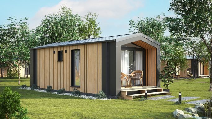 Modernes, kleines Holzhaus mit Terrasse und Garten, umgeben von Bäumen.